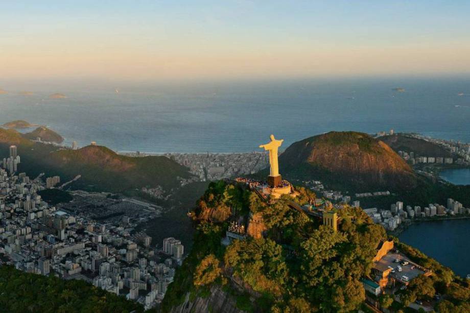No alto do Corcovado, a estátua do Cristo Redentor assoma sobre as baías e praias cariocas nesta imagem panorâmica No alto do Corcovado, a estátua do Cristo Redentor assoma sobre as baías e praias cariocas nesta imagem panorâmica