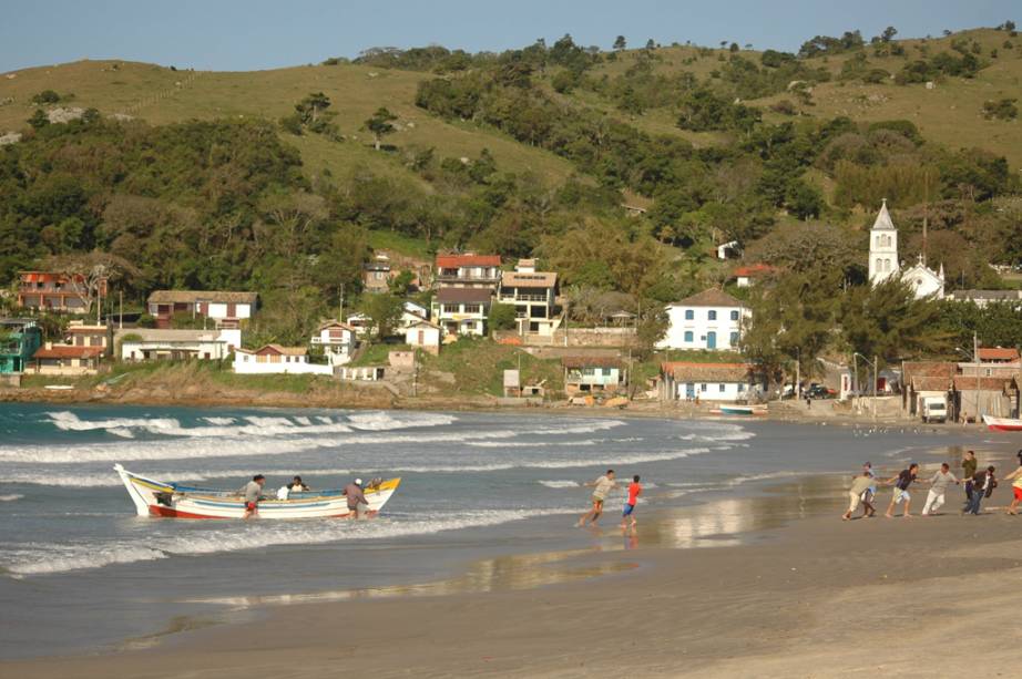 Pescadores na Praia de Garopaba, no centro comercial da cidade, e torre da Igreja Matriz ao fundo