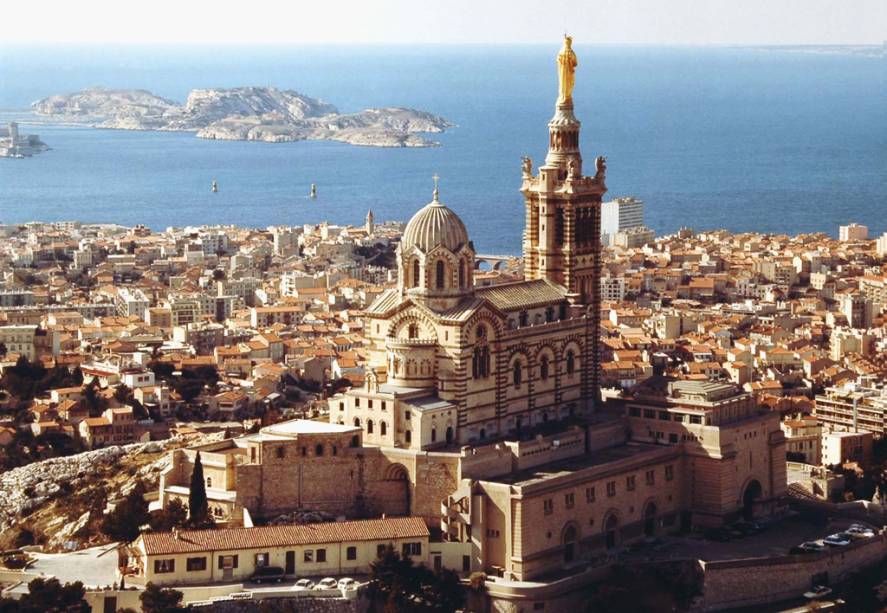 A 154 metros do nível do mar, a basílica de Notre Dame de la Garde, que simboliza Marselha, tem também a vista mais concorrida da cidade, principalmente no pôr do sol A 154 metros do nível do mar, a basílica de Notre Dame de la Garde, que simboliza Marselha, tem também a vista mais concorrida da cidade, principalmente no pôr do sol