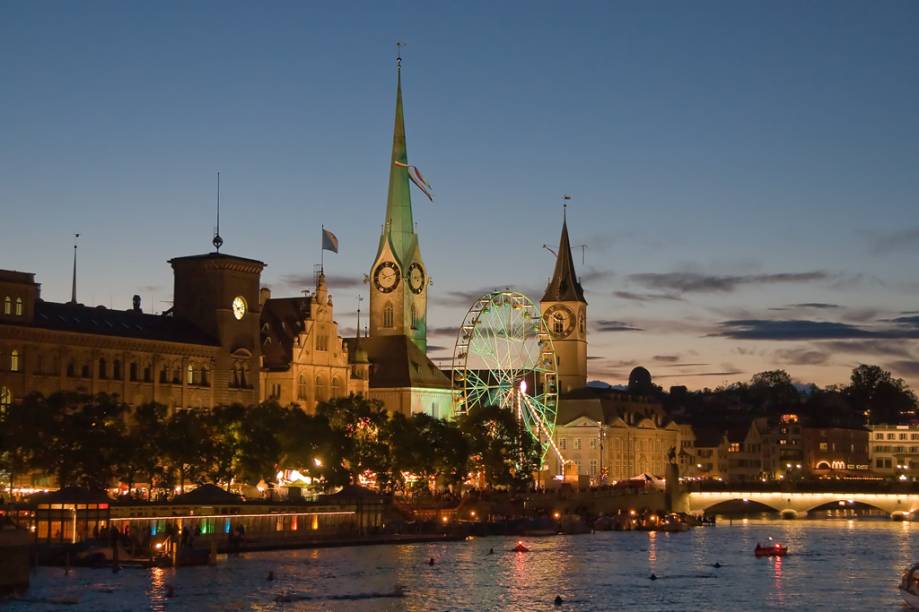Vista noturna das igrejas Fraumünster e St. Peterskirche, a partir do rio Limmat, em Zurique Vista noturna das igrejas Fraumünster e St. Peterskirche, a partir do rio Limmat, em Zurique