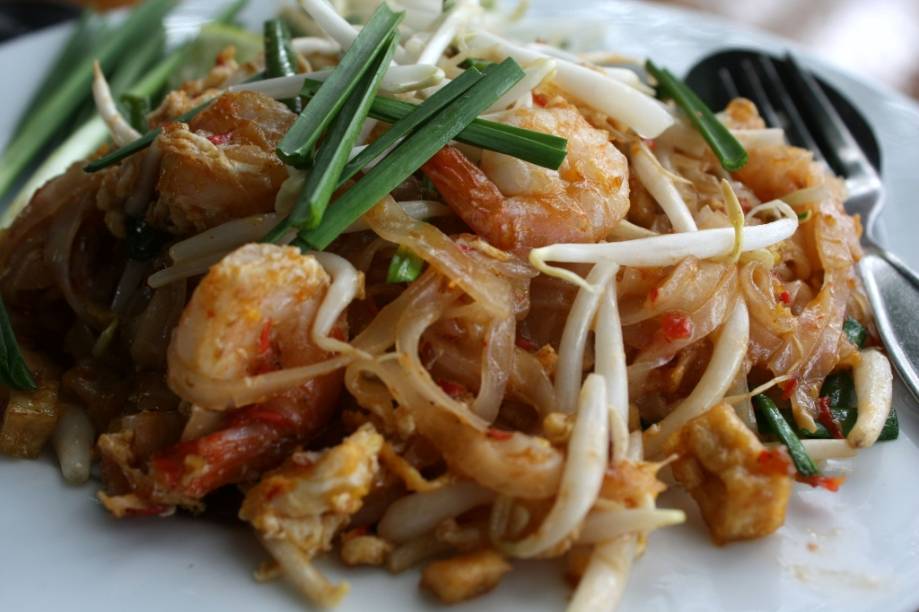 O prato símbolo da cozinha tailandesa é o <em>pad thai</em>. Essa espécide de yakisoba do sudeste asiático leva uma fileira interminável de ingredientes: macarrão de arroz, broto de feijão, cebolinha, pimenta, molho de tamarindo, açúcar, amendoim triturado, camarão seco, camarão fresco, ovo, broto de feijão, alho, limão, molho de peixe, frango, tofu, coentro e o que mais houver na geladeira