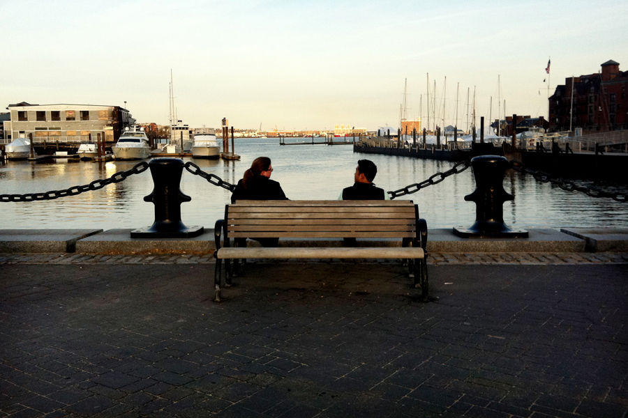 Pessoas relaxam no Waterfront, em frente ao Christopher Columbus Park