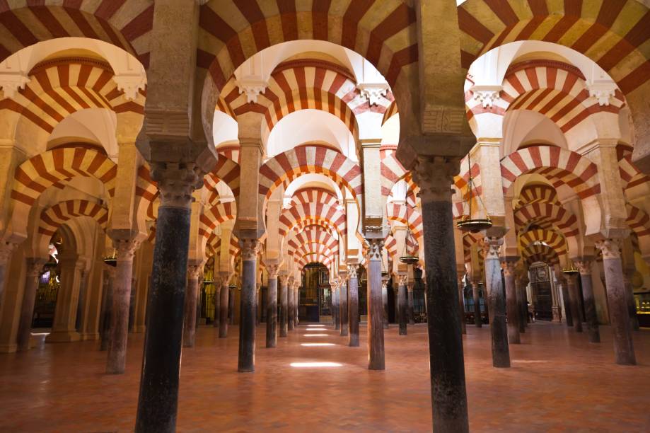 A Grande Mesquita de Córdoba é produto do califado que dominou o sul da Espanha entre 756 e 912. O amplo salão de orações, reformado pelo califa al-Hakan II, passou a contar com uma elegante solução de colunas intermináveis, encimadas por duas séries de arcos, oferecendo um sensação de movimento acentuado pelo jogo de luz e sombras A Grande Mesquita de Córdoba é produto do califado que dominou o sul da Espanha entre 756 e 912. O amplo salão de orações, reformado pelo califa al-Hakan II, passou a contar com uma elegante solução de colunas intermináveis, encimadas por duas séries de arcos, oferecendo um sensação de movimento acentuado pelo jogo de luz e sombras