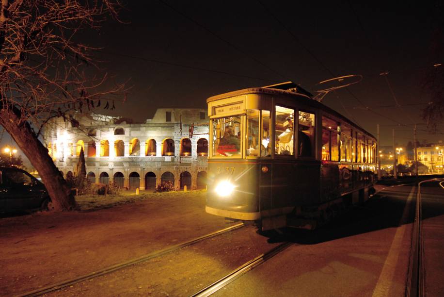 Vista noturna de bonde com o Coliseu Romano ao fundo Vista noturna de bonde com o Coliseu Romano ao fundo