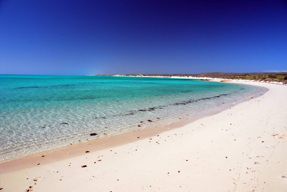 <strong>Costa de Ningaloo </strong>Trata-se de um dos maiores recifes do mundo perto da costa do continente, um paraíso para mergulhadores. As praias são maravilhosas, com areia branca e água cristalina. Se você tem planos de algum dia na vida mergulhar com tubarões, esse pode ser um bom destino: há passeios específicos para essa aventura