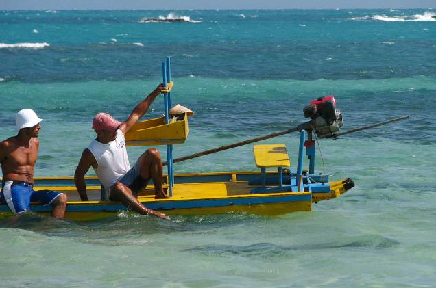 De vez em quando, pescadores aparecem em seus barquinhos para recolher o ganha-pão De vez em quando, pescadores aparecem em seus barquinhos para recolher o ganha-pão
