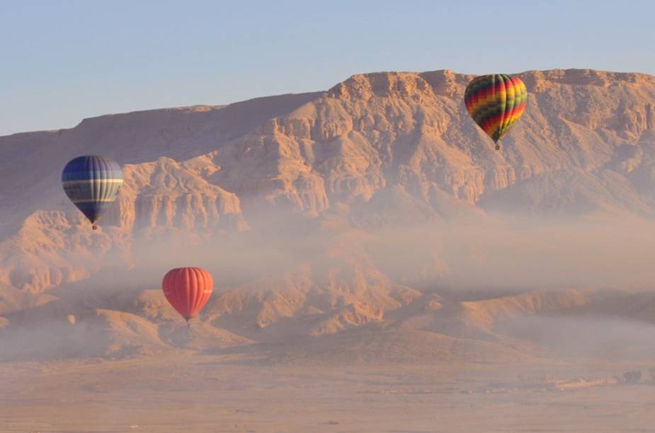 Um passeio de balão sobre <a href="https://beta-develop.viagemeturismo.abril.com.br/cidades/luxor/">Luxor</a>, no <a href="https://beta-develop.viagemeturismo.abril.com.br/paises/egito/">Egito</a>, permite ao passageiro uma vista exclusiva de riquezas da história egípcia como as colunas de Karnak, o Vale dos Reis, onde ficavam as tumbas dos faraós, e o Rio Nilo. Os balões coloridos contrastam com o marrom do solo e o azul do céu.