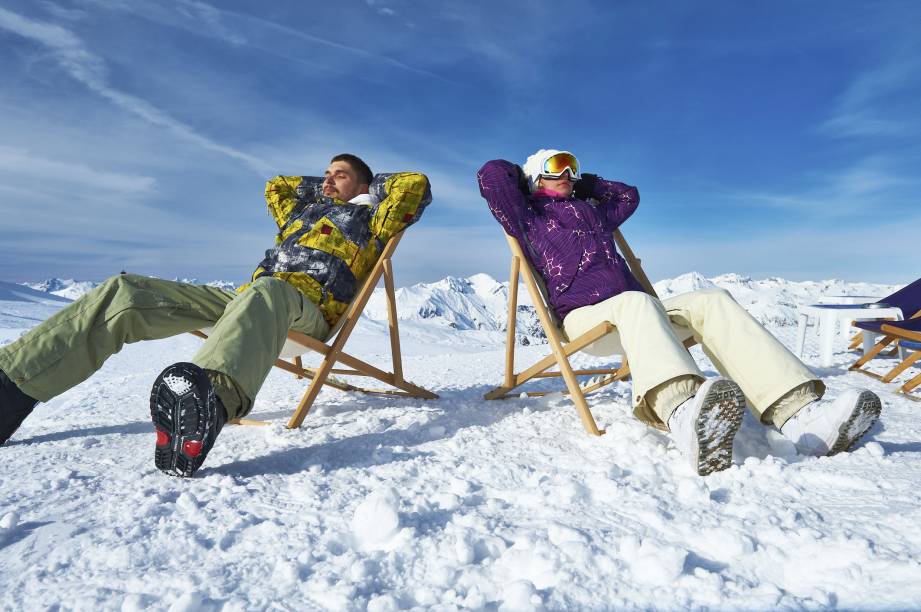 O après-ski: relaxadão, na neve, como se fosse praia; na foto, dois praticantes do esqui descansam no resort em <a href="https://viajeaqui.abril.com.br/materias/courchevel-conheca-a-vila-criada-para-ser-um-resort-de-esqui" rel="Courchevel" target="_blank">Courchevel</a>, nos <a href="https://viajeaqui.abril.com.br/cidades/franca-alpes-franceses" rel="Alpes Franceses" target="_blank">Alpes Franceses</a>