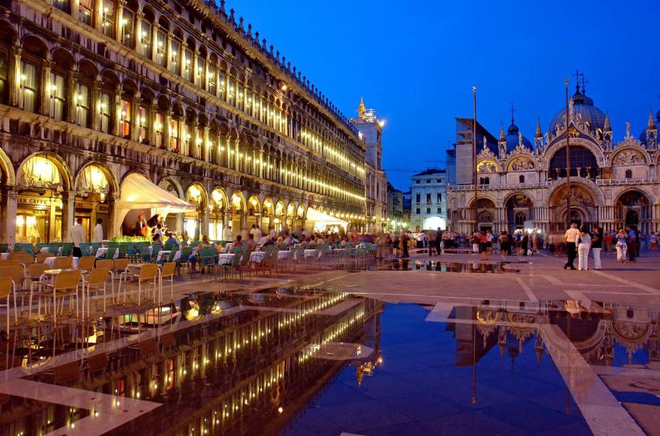 <strong>Piazza San Marco – <a href="https://beta-develop.viagemeturismo.abril.com.br/cidades/veneza-15/" target="_blank" rel="noopener">Veneza</a> – <a href="https://beta-develop.viagemeturismo.abril.com.br/paises/italia-2/" target="_blank" rel="noopener">Itália  </a></strong> Uma das mais belas e imponentes praças do mundo. A Piazza é um dos melhores pontos para curtir a paisagem e ver o povo passando por Veneza, mas também um dos lugares mais fortemente afetados durante as enchentes regulares da cidade, que são mais comuns durante o inverno. Para ver os museus que ficam na praça, é importante chegar cedo, antes da invasão de turistas. Sugerimos voltar à tardinha para o pôr do sol e quem sabe um café na <a href="https://viajeaqui.abril.com.br/estabelecimentos/italia-veneza-restaurante-caffe-florian" target="_blank" rel="noopener">Florian</a>, a cafeteria mais antiga da Itália. À noite, sua atmosfera é simplesmente mágica. Para conferir a melhor vista de Veneza, suba o elevador da <strong>torre do campanário </strong>que fica em um dos cantos da praça. Com sua primeira versão erguida no século 9, a torre desmoronou em 1902 e foi reconstruída de acordo com o projeto do século 16 <a href="https://www.booking.com/searchresults.pt-br.html?aid=332455&sid=d98f25c4d6d5f89238aebe98e11a09ba&sb=1&src=index&src_elem=sb&error_url=https%3A%2F%2Fwww.booking.com%2Findex.pt-br.html%3Faid%3D332455%3Bsid%3Dd98f25c4d6d5f89238aebe98e11a09ba%3Bsb_price_type%3Dtotal%26%3B&ss=Veneza%2C+Veneto%2C+It%C3%A1lia&is_ski_area=&ssne=Rio+de+Janeiro&ssne_untouched=Rio+de+Janeiro&checkin_year=&checkin_month=&checkout_year=&checkout_month=&group_adults=2&group_children=0&no_rooms=1&b_h4u_keep_filters=&from_sf=1&ss_raw=veneza&ac_position=0&ac_langcode=xb&ac_click_type=b&dest_id=-132007&dest_type=city&iata=VCE&place_id_lat=45.433891&place_id_lon=12.338505&search_pageview_id=ef6378843535029d&search_selected=true&search_pageview_id=ef6378843535029d&ac_suggestion_list_length=5&ac_suggestion_theme_list_length=0" target="_blank" rel="noopener"><em>Busque hospedagem em Veneza</em></a>