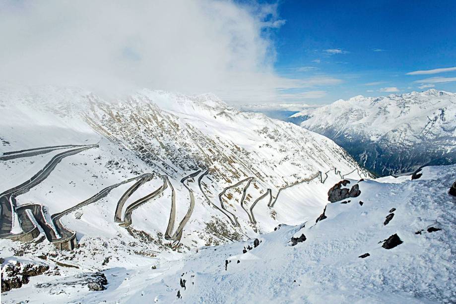 Ela sai de Davos, na <a href="https://viajeaqui.abril.com.br/paises/suica" target="_blank">Suíça</a>, e vai até Stelvio, na <a href="https://viajeaqui.abril.com.br/paises/italia" target="_blank">Itália</a>. O Passo Stelvio tem 60 curvas ao longo de 144 quilômetros, e curvas beeeem estreitas. Enquanto tenta não derrapar, o motorista pode exercitar a visão periférica espiando uma paisagem alpina absurdamente bonita, que vale cada viradinha no volante. A estrada passa por dentro do Parque Nacional de Stelvio, ao lado do lado di Livigno (felizmente em um trecho de 10 quilômetros em linha reta), pertinho de vacas balançando guizos. Tudo a prosaicos 2757 metros de altura Ela sai de Davos, na <a href="https://viajeaqui.abril.com.br/paises/suica" target="_blank">Suíça</a>, e vai até Stelvio, na <a href="https://viajeaqui.abril.com.br/paises/italia" target="_blank">Itália</a>. O Passo Stelvio tem 60 curvas ao longo de 144 quilômetros, e curvas beeeem estreitas. Enquanto tenta não derrapar, o motorista pode exercitar a visão periférica espiando uma paisagem alpina absurdamente bonita, que vale cada viradinha no volante. A estrada passa por dentro do Parque Nacional de Stelvio, ao lado do lado di Livigno (felizmente em um trecho de 10 quilômetros em linha reta), pertinho de vacas balançando guizos. Tudo a prosaicos 2757 metros de altura