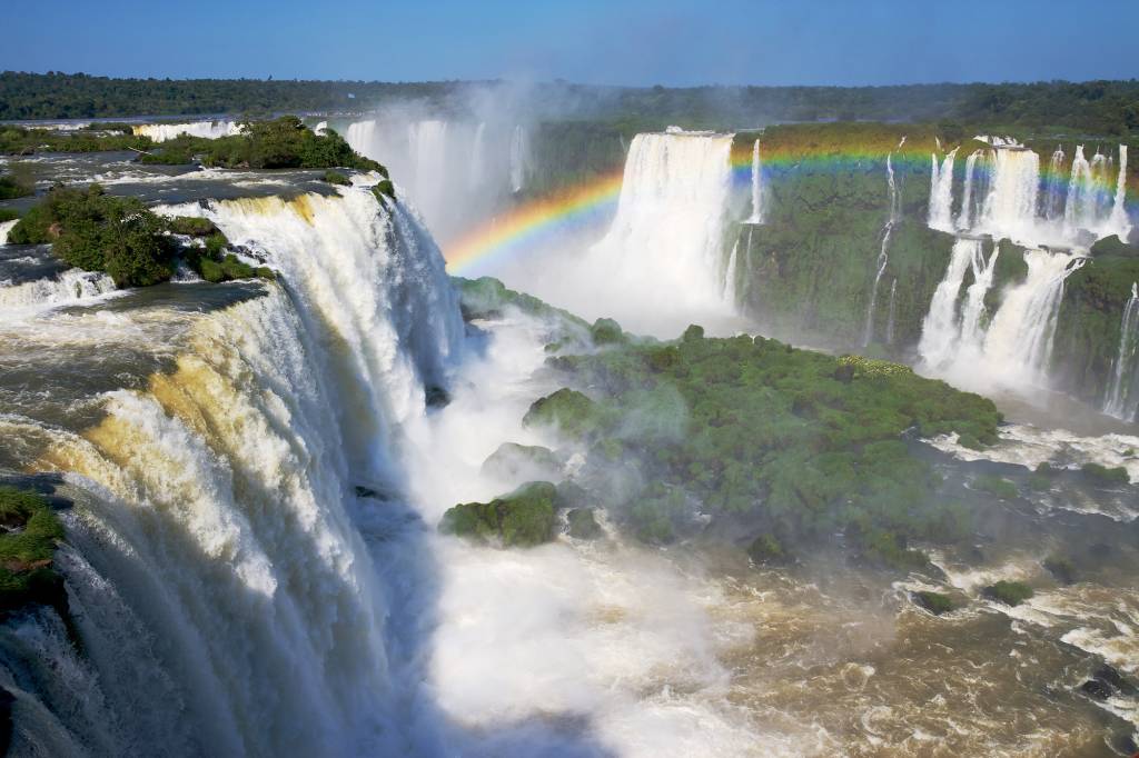 Vista do lado brasileiro das Cataratas; já o <a href="https://viajeaqui.abril.com.br/estabelecimentos/br-pr-foz-do-iguacu-atracao-parque-nacional-iguazu-argentina" rel="Parque Nacional Iguazú" target="_self">Parque Nacional Iguazú</a>, na  Argentina, impressiona pela força e a proximidade da Garganta do Diabo