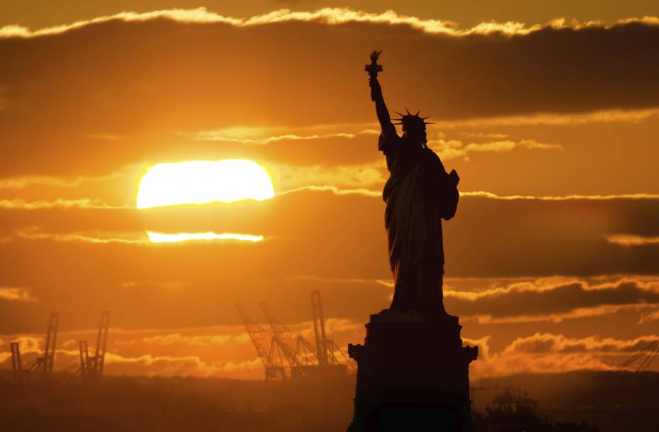 Pôr do sol em <a href="https://viajeaqui.abril.com.br/cidades/estados-unidos-nova-york" rel="Nova York" target="_blank">Nova York</a>, com a silhueta da <a href="https://viajeaqui.abril.com.br/estabelecimentos/estados-unidos-nova-york-atracao-estatua-da-liberdade-e-ellis-island" rel="Estátua da Liberdade" target="_blank">Estátua da Liberdade</a> Pôr do sol em <a href="https://viajeaqui.abril.com.br/cidades/estados-unidos-nova-york" rel="Nova York" target="_blank">Nova York</a>, com a silhueta da <a href="https://viajeaqui.abril.com.br/estabelecimentos/estados-unidos-nova-york-atracao-estatua-da-liberdade-e-ellis-island" rel="Estátua da Liberdade" target="_blank">Estátua da Liberdade</a>