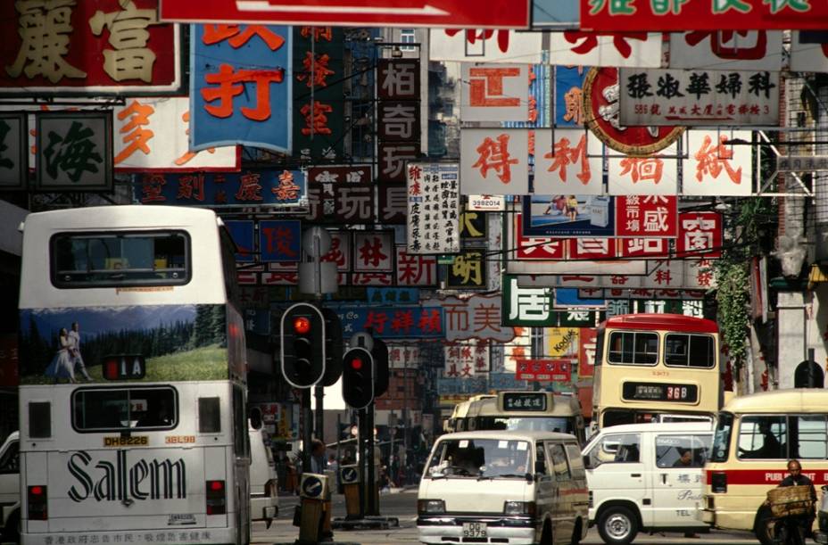 Placas em rua de Hong Kong. A escrita chinesa, também utilizada no Japão, começou a ser desenvolvida por volta do ano 1000 a.C., sendo padronizada durante a dinastia Qin, no século 3 a.C. Um chinês deve conhecer cerca de 5000 ideogramas para ser considerado plenamente alfabetizado.