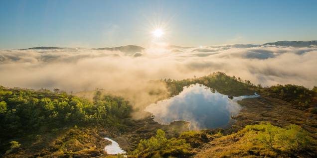 Acima das nuvens densas, o sol nasce arrebatador em Nordfjord, região oeste da Noruega Acima das nuvens densas, o sol nasce arrebatador em Nordfjord, região oeste da Noruega