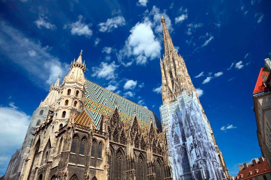 O telhado multicolorido e o grande campanário fazem da Catedral de Santo Estevão um dos principais ícones de Viena. Palco de fatos marcantes da história do império áustro-húngaro, o Stephansdom ainda guarda criptas e tumbas de figuras ilustres do país O telhado multicolorido e o grande campanário fazem da Catedral de Santo Estevão um dos principais ícones de Viena. Palco de fatos marcantes da história do império áustro-húngaro, o Stephansdom ainda guarda criptas e tumbas de figuras ilustres do país