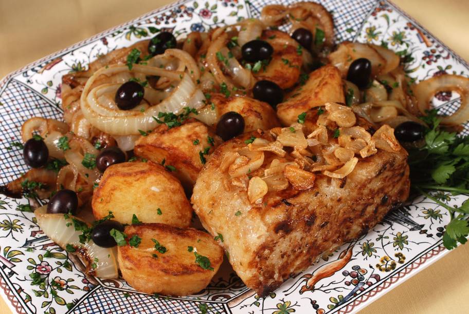 Bacalhau grelhado, polvilhado com alho ao forno, batatas douradas, rodelas de cebolas, azeitonas portuguesas e azeite extra virgem, do <a href="https://viajeaqui.abril.com.br/estabelecimentos/br-pe-recife-restaurante-tasca" rel="Tasca" target="_blank"><strong>Tasca</strong></a>, em <a href="https://viajeaqui.abril.com.br/cidades/br-pe-recife" rel="Recife" target="_blank"><strong>Recife</strong></a>. <em>Rua D. José Lopes, 165 (Boa Viagem). Tel. (81) 3326-6309</em>