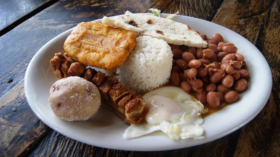 <strong>Bandeja Paisa, <a href="https://viajeaqui.abril.com.br/paises/colombia" rel="Colombia" target="_blank">Colombia</a></strong>        Se algum dia um mineiro subiu os Andes colombianos, foi ele o inventor da <em>bandeja paisa</em>. Uma mastodôntica combinação de diversos pratos chega à mesa para felicidade dos glutões e desespero (ou alegria, sei lá) das fofinhas. Vale tudo: arroz, feijão, ovo, carne moída, linguiça, torresmo, um bolinho chamado arepa e muito mais. Triglicérides, cheguei! <strong>Bandeja Paisa, <a href="https://viajeaqui.abril.com.br/paises/colombia" rel="Colombia" target="_blank">Colombia</a></strong>        Se algum dia um mineiro subiu os Andes colombianos, foi ele o inventor da <em>bandeja paisa</em>. Uma mastodôntica combinação de diversos pratos chega à mesa para felicidade dos glutões e desespero (ou alegria, sei lá) das fofinhas. Vale tudo: arroz, feijão, ovo, carne moída, linguiça, torresmo, um bolinho chamado arepa e muito mais. Triglicérides, cheguei!
