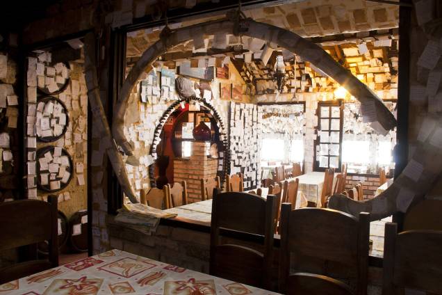 <strong><a href="https://viajeaqui.abril.com.br/estabelecimentos/br-sc-florianopolis-restaurante-bar-do-arante" rel="Bar do Arante" target="_blank">Bar do Arante</a> - <a href="https://viajeaqui.abril.com.br/cidades/br-sc-florianopolis" rel="Florianópolis" target="_blank">Florianópolis</a>, SC</strong><br /><br />A inevitável pergunta que os marinheiros de primeira viagem fazem ao se depararem com a rústica construção após atravessar toda a parte sul da ilha, por estradas de pista simples é: será que vale a pena? A dúvida começa a se dissipar ao ver o salão forrado com 70 mil bilhetinhos pendurados no teto e grudados na parede. Tanta demonstração de carinho por parte dos frequentadores sinaliza que, no mínimo, o local não deve ser ruim.<br /><br />A ótima cachacinha artesanal servida em um copinho de barro ameniza ainda mais a desconfiança. Que é dissipada completamente com a chegada dos fartos pratos de peixes e frutos do mar. A sequência de camarão enche o estômago de três pessoas, o peixe frito faz sucesso desde a inauguração no longínquo ano de 1958. Além dos pratos a la carte, um bufê é montado nos fins de semana.<br /><br />Onde: R. Abelardo Otacílio Gomes, 254, Pântano do Sul – Tel. (48) 3237-7022<br />Horário de funcionamento: segunda a domingo das 11h30 às 0h<br />Distância do Centro: 28 km <strong><a href="https://viajeaqui.abril.com.br/estabelecimentos/br-sc-florianopolis-restaurante-bar-do-arante" rel="Bar do Arante" target="_blank">Bar do Arante</a> - <a href="https://viajeaqui.abril.com.br/cidades/br-sc-florianopolis" rel="Florianópolis" target="_blank">Florianópolis</a>, SC</strong><br /><br />A inevitável pergunta que os marinheiros de primeira viagem fazem ao se depararem com a rústica construção após atravessar toda a parte sul da ilha, por estradas de pista simples é: será que vale a pena? A dúvida começa a se dissipar ao ver o salão forrado com 70 mil bilhetinhos pendurados no teto e grudados na parede. Tanta demonstração de carinho por parte dos frequentadores sinaliza que, no mínimo, o local não deve ser ruim.<br /><br />A ótima cachacinha artesanal servida em um copinho de barro ameniza ainda mais a desconfiança. Que é dissipada completamente com a chegada dos fartos pratos de peixes e frutos do mar. A sequência de camarão enche o estômago de três pessoas, o peixe frito faz sucesso desde a inauguração no longínquo ano de 1958. Além dos pratos a la carte, um bufê é montado nos fins de semana.<br /><br />Onde: R. Abelardo Otacílio Gomes, 254, Pântano do Sul – Tel. (48) 3237-7022<br />Horário de funcionamento: segunda a domingo das 11h30 às 0h<br />Distância do Centro: 28 km