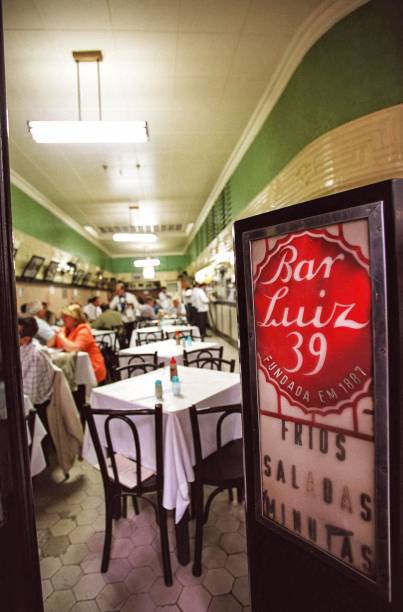 <strong>PARA CURTIR O CENTRO E ARREDORES</strong> <strong><a href="https://pt-br.facebook.com/restaurantebarluiz/" target="_blank" rel="noopener">Bar Luiz</a> </strong>Decano da boemia carioca, foi inaugurado em 1887 – antes da Abolição da Escravatura e da Proclamação da República. Naqueles tempos, ficava na Rua da Assembleia e era conhecido como “Braço de Ferro” devido ao costume do dono, o alemão Adolf Rumjaneck, de desafiar os fregueses na queda de braço para promover o consumo do chope (então menos prestigiado do que o vinho). O estabelecimento mudou-se para o endereço atual em 1927, como Bar Adolf, e foi rebatizado nos anos 1940, quando estudantes tentaram destruir o local numa manifestação contra o fascismo – o bar foi salvo pela intervenção do compositor (e cliente) Ary Barroso. A partir daí virou Bar Luiz, aportuguesando o nome do proprietário da época, Ludwig Vöit. A origem germânica da casa faz-se ainda hoje presente na cozinha, de onde saem pedidos tradicionais como salada de batata, kassler e salsichão <em>R. da Carioca, 39 (Centro), (21) 2262-6900</em> <strong>PARA CURTIR O CENTRO E ARREDORES</strong> <strong><a href="https://pt-br.facebook.com/restaurantebarluiz/" target="_blank" rel="noopener">Bar Luiz</a> </strong>Decano da boemia carioca, foi inaugurado em 1887 – antes da Abolição da Escravatura e da Proclamação da República. Naqueles tempos, ficava na Rua da Assembleia e era conhecido como “Braço de Ferro” devido ao costume do dono, o alemão Adolf Rumjaneck, de desafiar os fregueses na queda de braço para promover o consumo do chope (então menos prestigiado do que o vinho). O estabelecimento mudou-se para o endereço atual em 1927, como Bar Adolf, e foi rebatizado nos anos 1940, quando estudantes tentaram destruir o local numa manifestação contra o fascismo – o bar foi salvo pela intervenção do compositor (e cliente) Ary Barroso. A partir daí virou Bar Luiz, aportuguesando o nome do proprietário da época, Ludwig Vöit. A origem germânica da casa faz-se ainda hoje presente na cozinha, de onde saem pedidos tradicionais como salada de batata, kassler e salsichão <em>R. da Carioca, 39 (Centro), (21) 2262-6900</em>