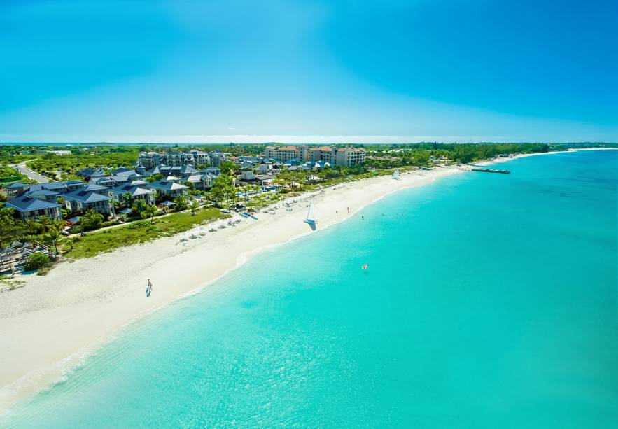 <strong><a href="https://www.beaches.com/main/tc/tc-home/" rel="Beaches Turks and Caicos Resort Villages and Spa" target="_blank">Beaches Turks and Caicos Resort Villages and Spa</a> – Ilhas Turcas e Caicos</strong>Parques aquáticos para crianças, mergulho ilimitado, serviço de mordomo pessoal, entretenimento dia e noite, vinhos de qualidade e drinks ilimitados são algumas das atrações que chamam a atenção para este resort. Aí você vê a foto da praia particular em frente a ele e já se convence que é pra lá que precisa ir nas próximas férias. Esportes aquáticos com e sem motor, como esqui-aquático, caiaque, snorkel, windsurf e barcos com fundo de vidro também estão todos incluídos na diária