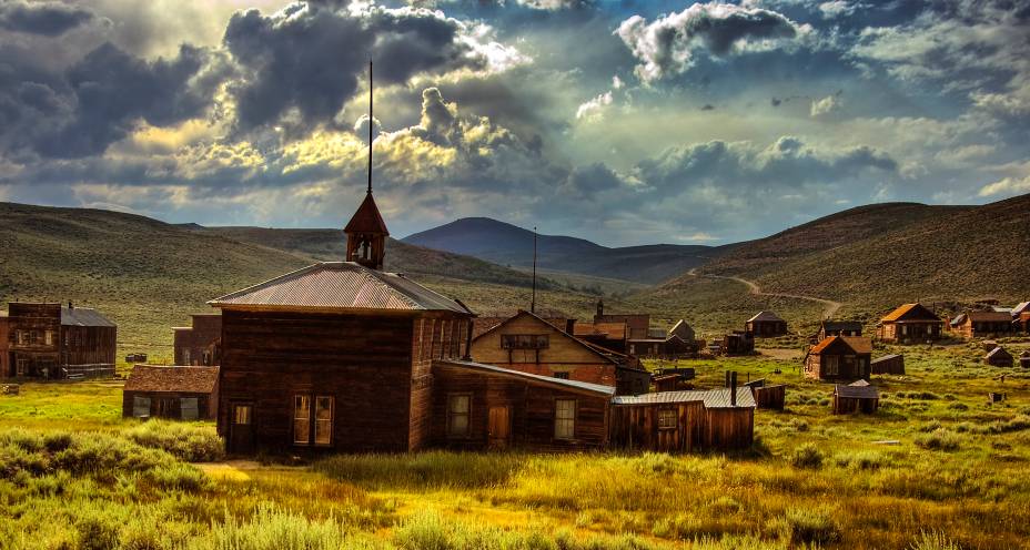 <strong>Vilarejo de Bodie, Califórnia, <a href="https://viajeaqui.abril.com.br/paises/estados-unidos" rel="Estados Unidos" target="_blank">Estados Unidos</a></strong>    Localizada na região de Serra Nevada, essa pequena vila com clima de Velho Oeste faz parte de um conjunto de mais de seis mil cidades-fantasmas de extrema importância para a cultura nacional. Todas elas, aliás, foram fundamentais para o desenvolvimento da Corrida de Ouro e de metais preciosos no final do século 19. Bodie, em particular, soube preservar suas características mesmo depois do abandono por parte de seus moradores, que deixaram suas casas para trás depois que o comércio e exploração de metais começou a degringolar, e dos atos de vandalismo e incêndios. As casas de madeira, a decoração e os objetos pessoais da população encontram-se bem preservados e conferiram três títulos de respeito para a vila que, no passado, foi marcada como segundo centro urbano mais importante da Califórnia, atrás somente de <a href="https://viajeaqui.abril.com.br/cidades/estados-unidos-los-angeles" rel="Los Angeles" target="_blank">Los Angeles</a>: o de Registro Nacional de Lugares Históricos, o de Distrito Histórico Nacional dos Estados Unidos e de Marco Histórico da Califórnia