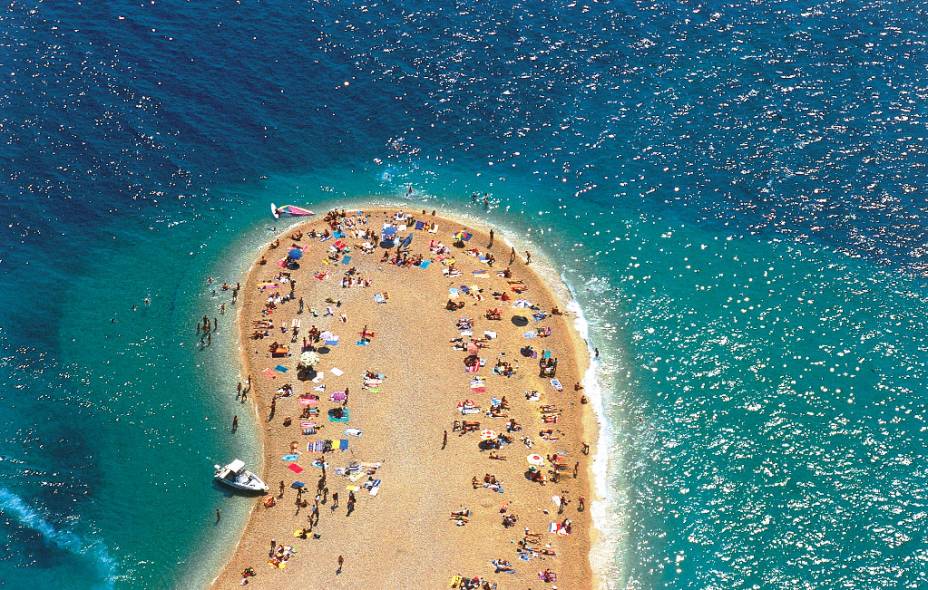 Detalhe da ponta da praia de Zlati Rat, uma pequena península de areia na ilha de Brač, perto da cidade de Bol    <a href="https://www.booking.com/city/hr/bol.pt-br.html?aid=332455&label=viagemabril-croacia" rel="Veja preços de hotéis próximos à praia de Zlatni Rat no Booking.com" target="_blank">Veja preços de hotéis próximos à praia de Zlatni Rat no Booking.com</a>