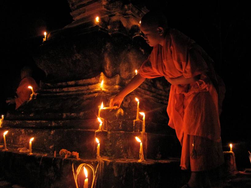 Aprendiz de monge acende vela durante o FEstiva Boun Ok Phansa, em Luang Prabang Aprendiz de monge acende vela durante o FEstiva Boun Ok Phansa, em Luang Prabang