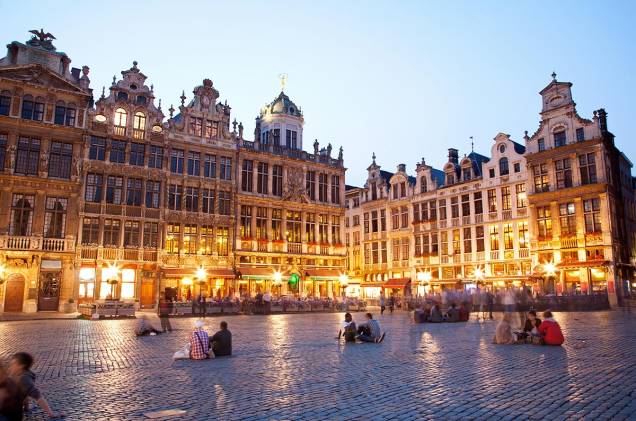 <a href="https://viajeaqui.abril.com.br/estabelecimentos/belgica-bruxelas-atracao-grand-place" rel="Grand-Place – Bruxelas – Bélgica" target="_blank"><strong>Grand-Place – Bruxelas – Bélgica</strong></a><a href="https://viajeaqui.abril.com.br/estabelecimentos/belgica-bruxelas-atracao-grand-place" rel="Grand-Place – Bruxelas – Bélgica" target="_blank"><strong> </strong></a> Com a agulha da prefeitura dominando o entorno, a Grand Place de Bruxelas é o centro da vida comercial e cívica da cidade a quase mil anos. A combinação de vários estilos arquitetônicos que decoram as casas das guildas e sua rica história lhe valeram o título de Patrimônio da Humanidade pela Unesco. As poderosas guildas comerciais belgas mantinham suas sedes na praça – elas fecharam no século 18 e suas belas casas entrariam em acelerado processo de deterioração até voltarem a ser restauradas décadas mais tarde. Com 96 metros de altura, o prédio mais imponente é o da Prefeitura, construído entre 1402 e 1455. É possível fazer uma visita guiada por dentro do lugar, repleto de objetos de arte. Outro prédio famoso que cerca a Grand Place é o da Casa do Rei, também do século 15, onde fica o Museu de Bruxelas. Quem não estiver afim de andar, pode simplesmente parar em um café e apreciar o visual comendo um waffle típico belga. Durante a noite a praça fica toda iluminada e ainda mais bonita. Todo ano par, no mês de agosto, a Grand Place é coberta com um tapete de flores que chega a ter 500 mil plantas! <a href="https://viajeaqui.abril.com.br/estabelecimentos/belgica-bruxelas-atracao-grand-place" rel="Grand-Place – Bruxelas – Bélgica" target="_blank"><strong>Grand-Place – Bruxelas – Bélgica</strong></a><a href="https://viajeaqui.abril.com.br/estabelecimentos/belgica-bruxelas-atracao-grand-place" rel="Grand-Place – Bruxelas – Bélgica" target="_blank"><strong> </strong></a> Com a agulha da prefeitura dominando o entorno, a Grand Place de Bruxelas é o centro da vida comercial e cívica da cidade a quase mil anos. A combinação de vários estilos arquitetônicos que decoram as casas das guildas e sua rica história lhe valeram o título de Patrimônio da Humanidade pela Unesco. As poderosas guildas comerciais belgas mantinham suas sedes na praça – elas fecharam no século 18 e suas belas casas entrariam em acelerado processo de deterioração até voltarem a ser restauradas décadas mais tarde. Com 96 metros de altura, o prédio mais imponente é o da Prefeitura, construído entre 1402 e 1455. É possível fazer uma visita guiada por dentro do lugar, repleto de objetos de arte. Outro prédio famoso que cerca a Grand Place é o da Casa do Rei, também do século 15, onde fica o Museu de Bruxelas. Quem não estiver afim de andar, pode simplesmente parar em um café e apreciar o visual comendo um waffle típico belga. Durante a noite a praça fica toda iluminada e ainda mais bonita. Todo ano par, no mês de agosto, a Grand Place é coberta com um tapete de flores que chega a ter 500 mil plantas!