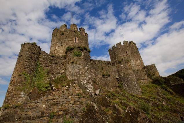 Construído sobre um promontório rochoso por Eduardo I, o Castelo de Conwy faz parte do esforço do monarca em garantir suas conquistas em Gales, no século 13. Juntamente com outros três castelos, incluindo Caernarforn, Conwy faz parte do patrimônio da humanidade Construído sobre um promontório rochoso por Eduardo I, o Castelo de Conwy faz parte do esforço do monarca em garantir suas conquistas em Gales, no século 13. Juntamente com outros três castelos, incluindo Caernarforn, Conwy faz parte do patrimônio da humanidade