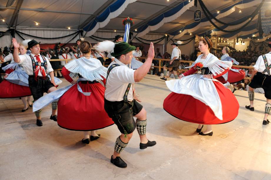 <strong>Alemanha: dirndl e lederhosen</strong> A roupa mais típica e tradicional da Alemanha é o lederhosen para os homens e, para as mulheres, o dirndl. Originalmente, era a vestimenta dos camponeses alpinos, mas hoje é utilizada em festas e comemorações de ascendência germânica. A versão feminina conta com um corpete com babados do decote, uma camisa por baixo e um avental - geralmente xadrez - sobre uma saia. Já o traje masculino consiste de calças de couro acima do joelho, suspensórios, um chapéu com uma pena e meias altas