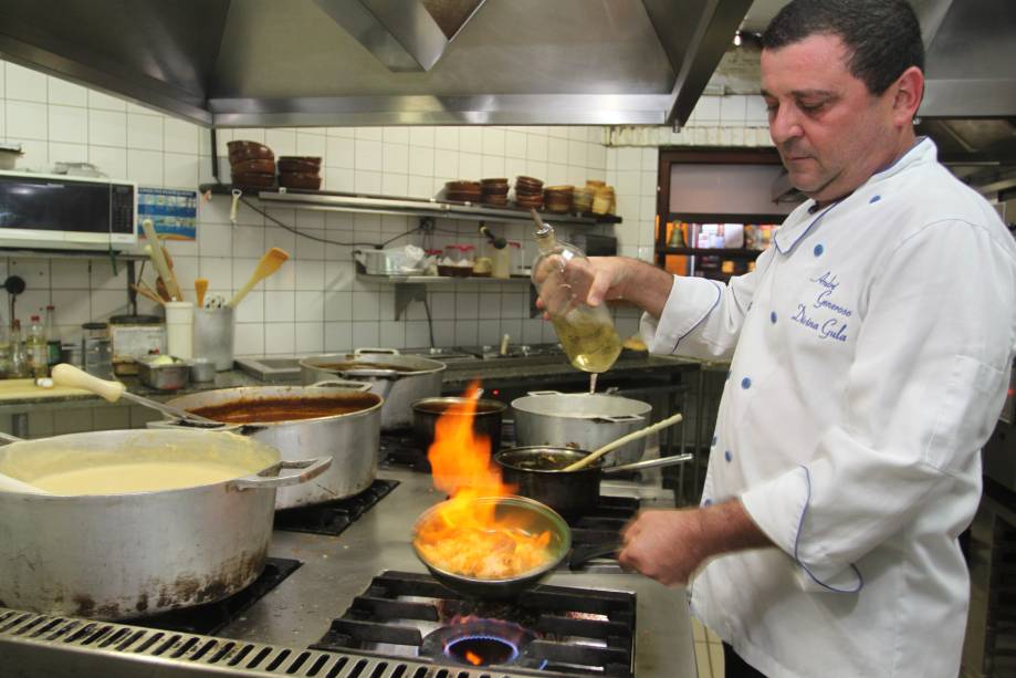 O chef Andr&eacute; Generoso flamba o peixe grelhado com uvas e legumes
