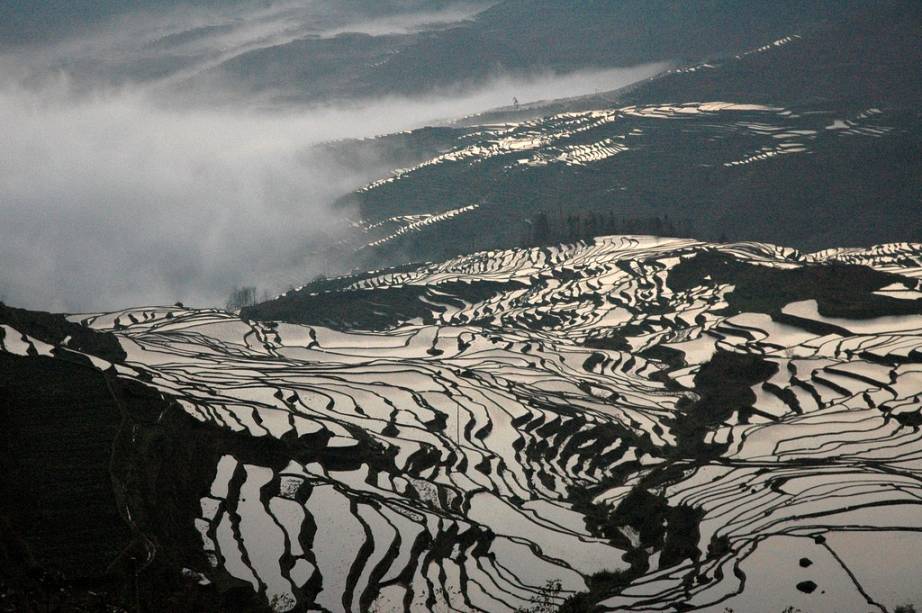 <strong>Dragon Backbone Rice Fields, Longsheng, Guangxi, China</strong> O terreno montanhoso da província de Guangxi desafiou os locais a construir plantações alagadas de arroz adaptadas à sua geografia. Esta é uma paisagem criada pelo homem, mas não deixa de ter grande apelo natural. <a href="https://www.booking.com/searchresults.pt-br.html?aid=332455&lang=pt-br&sid=eedbe6de09e709d664615ac6f1b39a5d&sb=1&src=index&src_elem=sb&error_url=https%3A%2F%2Fwww.booking.com%2Findex.pt-br.html%3Faid%3D332455%3Bsid%3Deedbe6de09e709d664615ac6f1b39a5d%3Bsb_price_type%3Dtotal%26%3B&ss=China&ssne=Ilhabela&ssne_untouched=Ilhabela&checkin_monthday=&checkin_month=&checkin_year=&checkout_monthday=&checkout_month=&checkout_year=&no_rooms=1&group_adults=2&group_children=0&from_sf=1&ss_raw=China+&ac_position=0&ac_langcode=xb&dest_id=44&dest_type=country&search_pageview_id=a5a173e6a6c40073&search_selected=true&search_pageview_id=a5a173e6a6c40073&ac_suggestion_list_length=5&ac_suggestion_theme_list_length=0" target="_blank" rel="noopener"><em>Busque hospedagens na China no Booking.com</em></a>