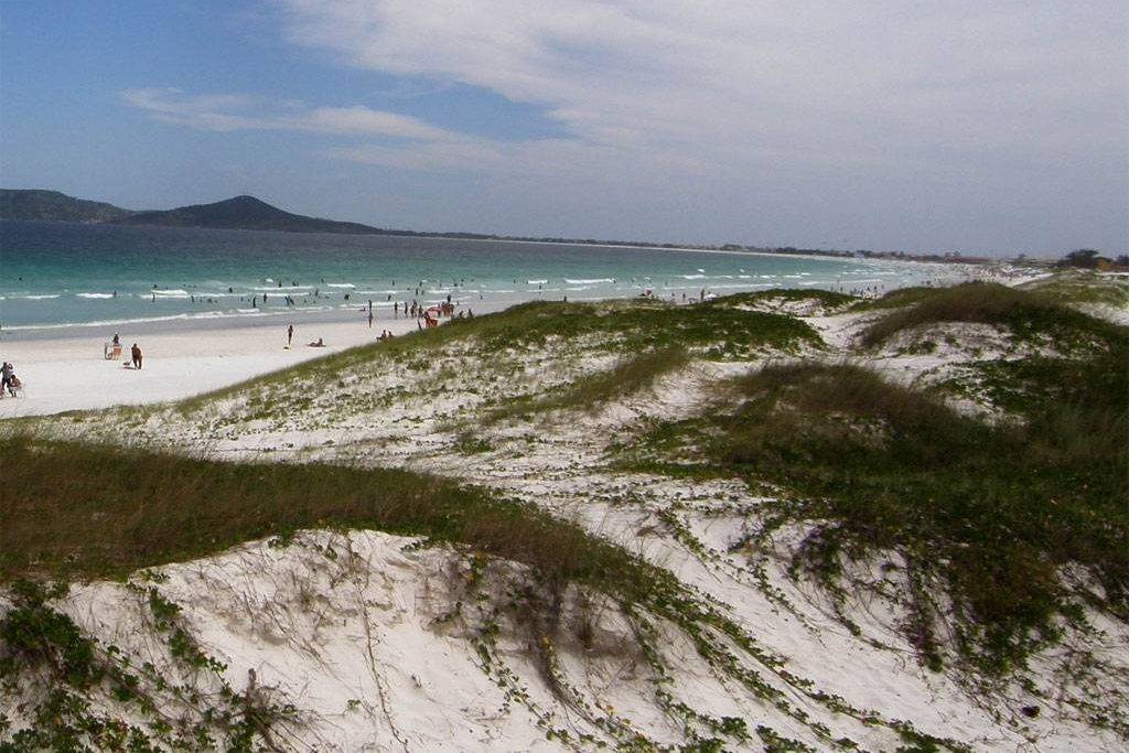 <strong>15. <a href="https://viajeaqui.abril.com.br/estabelecimentos/br-rj-cabo-frio-atracao-praia-das-dunas" rel="Praia das Dunas" target="_blank">Praia das Dunas</a>&nbsp;</strong><strong>&ndash;</strong><strong>&nbsp;<a href="https://viajeaqui.abril.com.br/cidades/br-rj-cabo-frio" rel="Cabo Frio (RJ)" target="_blank">Cabo Frio (RJ)</a></strong>    Localizada a dois quil&ocirc;metros do centro de Cabo Frio, a <a href="https://viajeaqui.abril.com.br/estabelecimentos/br-rj-cabo-frio-atracao-praia-das-dunas" rel="Praia das Dunas" target="_self">Praia das Dunas</a> n&atilde;o tem este nome &agrave; toa. Apesar de n&atilde;o ter muitos montes altos, as dunas de l&aacute; s&atilde;o preservadas e n&atilde;o sofreram altera&ccedil;&otilde;es urbanas &ndash; &eacute; uma &Aacute;rea de Prote&ccedil;&atilde;o Ambiental e, portanto, totalmente deserta. &Eacute; procurada pelos surfistas por causa do mar de ondas fortes, mas, tirando eles, que est&atilde;o na &aacute;gua, n&atilde;o h&aacute; quase ningu&eacute;m nas areias, por isto n&atilde;o &eacute; recomend&aacute;vel conhecer a &aacute;rea sozinho