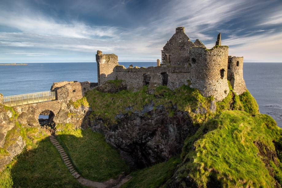O Castelo de Dunluce, em Antrim, na Irlanda do Norte, reúne amplas e belas ruínas à beira de um precipício. Ele pode ser acessado através de uma ponte, nas proximidades de Bushmills O Castelo de Dunluce, em Antrim, na Irlanda do Norte, reúne amplas e belas ruínas à beira de um precipício. Ele pode ser acessado através de uma ponte, nas proximidades de Bushmills