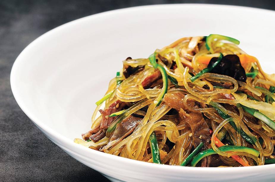 <strong>Japchae</strong>    Se você for a uma festa coreana, provavelmente vai encontrar japchae. O prato é servido em ocasiões especiais. Trata-se de macarrão de batata-doce (o dangmyeon), refogado com espinafre, cenoura, cogumelos, carne e cebolas fritas