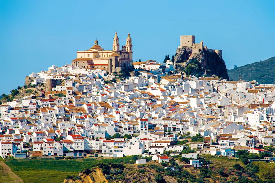 <strong>2. Olvero, Espanha</strong> Uma das 19 cidadezinhas que integram a rota dos Pueblos Blancos, Olvero honra o encantador padrão dessa faixa da Andaluzia, na Espanha. É cheia de casas caiadas de branco (para espantar o calorão) que sobem e descem nos morros. E é de uma brancura de ofuscar a vista. Mas a particularidade de Olvero é o efeito altamente cenográfico da igreja e da torre do castelo medieval, medindo forças lá no alto