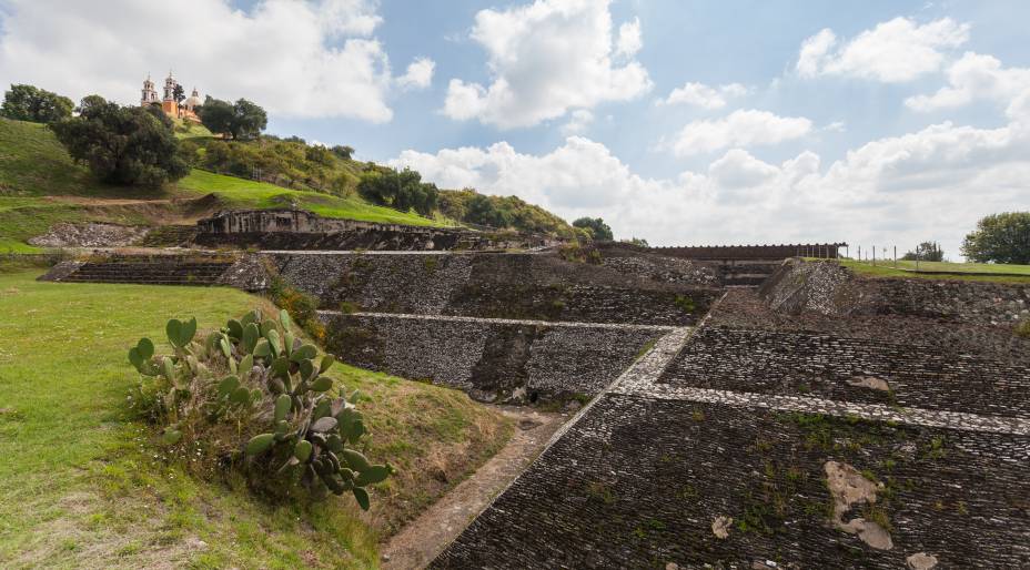 <strong>6. Grande Pirâmide de Cholula – San Andrés Cholula – México </strong>Durante mais de mil anos o local teve importância religiosa e mística, até que foi abandonado em favor de um novo templo. Durante a conquista espanhola foi construída a igreja dedicada à Virgem dos Remédios em seu topo, estratégia comum entre os dominadores de construir monumentos católicos em locais sagrados de outras religiões.A pirâmide faz parte do maior complexo arqueológico mesoamericano, localizado a 6 km de Puebla (cidade histórica colonial bastante próxima à Cidade do México). Sua construção foi dedicada ao deus Quetzalcoatl, a serpente emplumada, e também relacionada à deusa das nove chuvas Chiconauhquiauhitl. É possível entrar por túneis e conhecer a pirâmide por dentro, uma experiência rara entre as pirâmides mesoamericanas