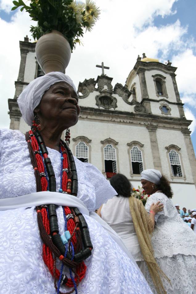 A <a href="https://viajeaqui.abril.com.br/estabelecimentos/br-ba-salvador-atracao-igreja-senhor-do-bonfim" rel="Igreja Senhor do Bonfim" target="_blank"><strong>Igreja Senhor do Bonfim</strong></a> leva o nome do padroeiro dos baianos e é também símbolo do sincretismo religioso na cidade. A tradição de lavar a escadaria e o adro começou com os escravos, como preparativo para a festa em homenagem ao santo, e é mantida até hoje pelas baianas do candomblé (à esq.). Outra marca sincrética é a famosa fitinha (à dir.): ninguém sai daqui sem amarrá-la no pulso ou no portão. A <a href="https://viajeaqui.abril.com.br/estabelecimentos/br-ba-salvador-atracao-igreja-senhor-do-bonfim" rel="Igreja Senhor do Bonfim" target="_blank"><strong>Igreja Senhor do Bonfim</strong></a> leva o nome do padroeiro dos baianos e é também símbolo do sincretismo religioso na cidade. A tradição de lavar a escadaria e o adro começou com os escravos, como preparativo para a festa em homenagem ao santo, e é mantida até hoje pelas baianas do candomblé (à esq.). Outra marca sincrética é a famosa fitinha (à dir.): ninguém sai daqui sem amarrá-la no pulso ou no portão.