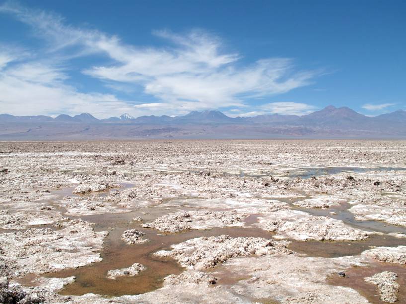 No <a href="https://viajeaqui.abril.com.br/estabelecimentos/chile-san-pedro-de-atacama-atracao-salar-do-atacama">Salar do Atacama</a>, impressionam as grandes áreas cobertas de crostas de sal na superfície, formadas pela constante acumulação de cristais produzidos pela evaporação de águas subterrâneas com alta carga de sais