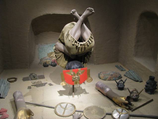 Reprodução de um dos enterros da elite sicán nas tumbas leste e oeste de Huaca El Loro: personagem foi encontrado de cabeça para baixo com máscara na posição convencional Reprodução de um dos enterros da elite sicán nas tumbas leste e oeste de Huaca El Loro: personagem foi encontrado de cabeça para baixo com máscara na posição convencional