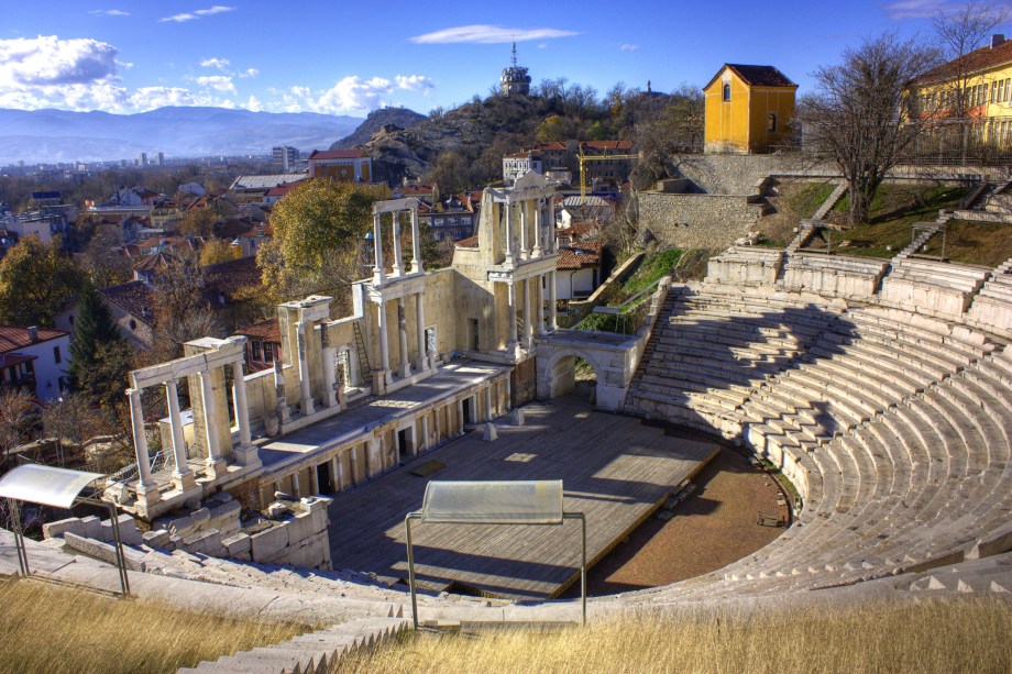 <strong><a href="https://ancient-stadium-plovdiv.eu/" target="_blank" rel="noopener">Teatro Romano</a>, Plovdiv, Bulgária</strong> Considerado um dos teatros antigos mais preservados do mundo, o Teatro Romano de Plovdiv encanta visitantes com suas colunas de mármore. Erguido durante o reinado do Imperador Trajano durante o século II, o auditório, que inclui uma capacidade de até 5 mil espectadores, teria sido danificado com as invasões do sanguinário Átila, o Huno. Muitos dizem que as ruínas só foram restauradas em 1970, em um processo lento e minucioso que buscou preservar suas características originais. Hoje, esse belo cenário abriga discretas apresentações de danças, teatro e concertos