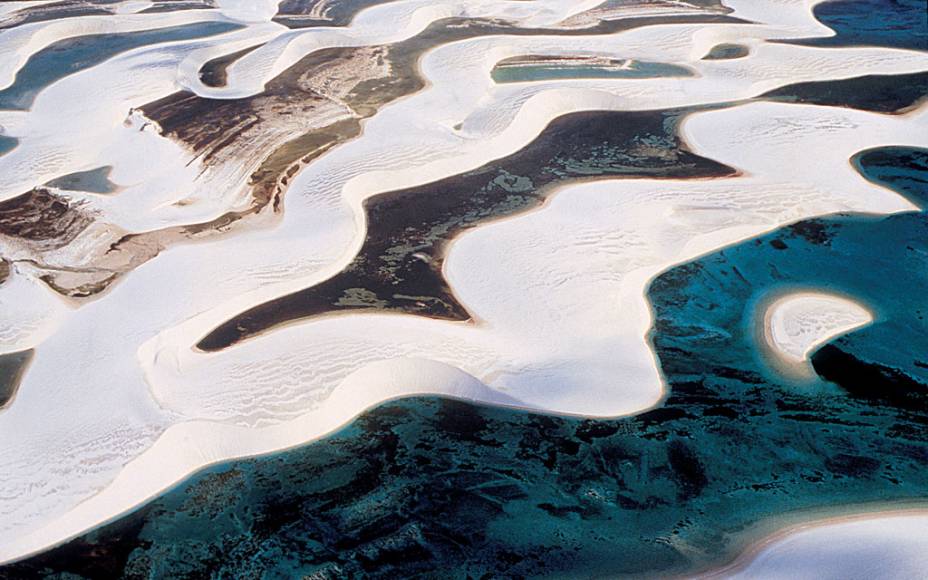 Os <a href="https://viajeaqui.abril.com.br/estabelecimentos/br-ma-barreirinhas-atracao-parque-nacional-dos-lencois-maranhenses" rel="Lençóis Maranhenses" target="_self"><strong>Lençóis Maranhenses</strong></a> (MA) compõem uma das paisagens mais cênicas do país, com uma área cercada por dunas, rios, lagoas e manguezais. A água cor de esmeralda revela a presença de pequenos peixes, que fazem companhia ao visitante que decide entrar nela 