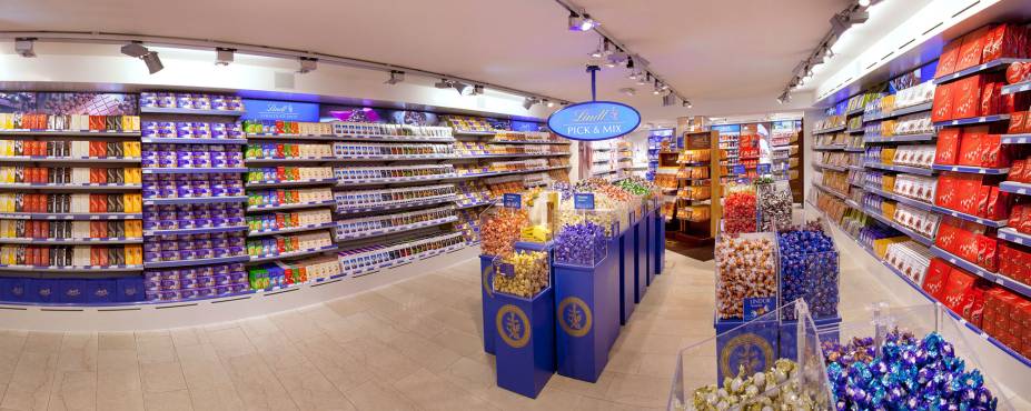 <strong>Lindt – Kilchberg, <a href="https://viajeaqui.abril.com.br/paises/suica" rel="Suíça" target="_blank">Suíça</a></strong>                            Em qualquer lugar da Suíça, e do mundo, estão as lojas das agraciadas barras de chocolate e bombons Lindt. Acontece que a unidade da comuna de Kilchberg, pertinho de Zurique, tem um quê especial: fica no mesmo local da fábrica da marca. Chocolate literalmente recém-nascido