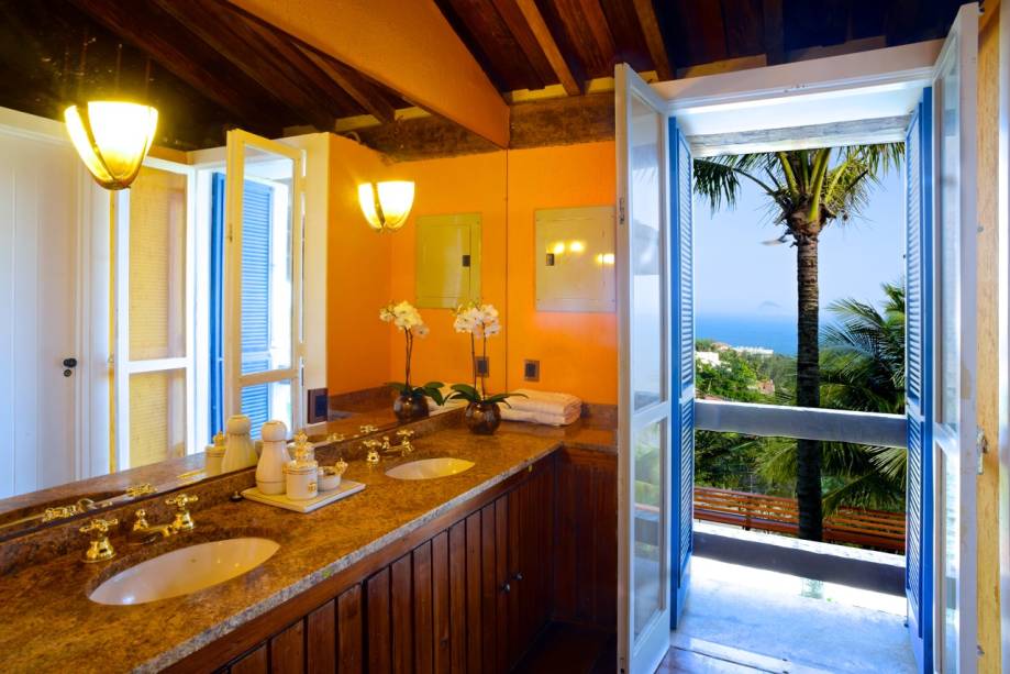 No banheiro com duas cubas e metais dourados (detalhes importam), a porta de folha dupla descortina a natureza. Preço da casa: US$ 2 922 por noite, para até 8 hóspedes, o que dá cerca de R$ 1 315 por pessoa (ouch!) No banheiro com duas cubas e metais dourados (detalhes importam), a porta de folha dupla descortina a natureza. Preço da casa: US$ 2 922 por noite, para até 8 hóspedes, o que dá cerca de R$ 1 315 por pessoa (ouch!)