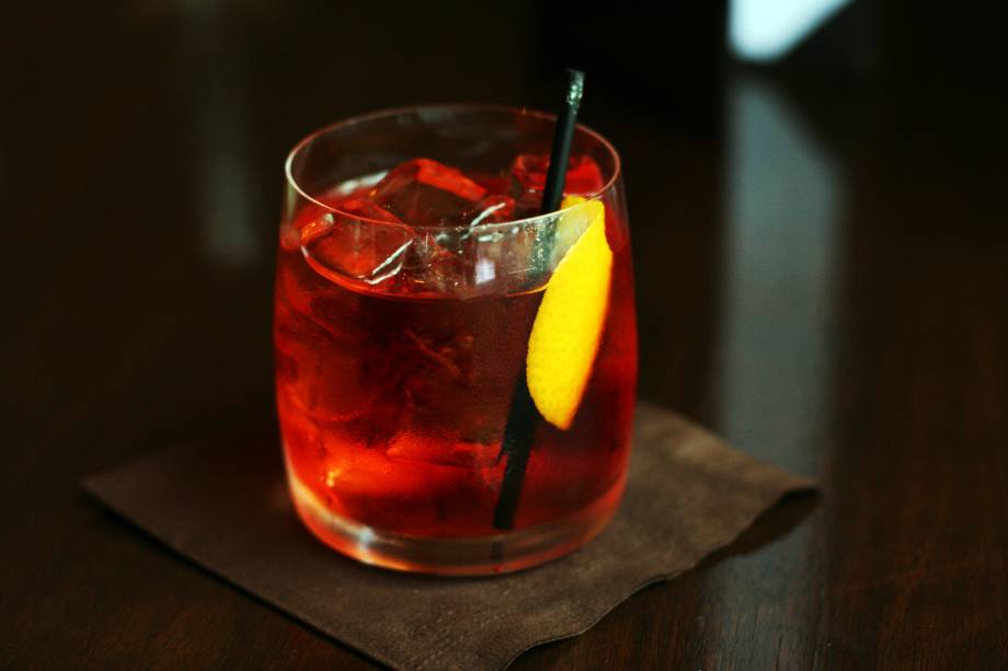 <strong>11. Negroni – <a href="https://viajeaqui.abril.com.br/cidades/italia-florenca-firenze" rel=" Florença – Itália " target="_blank">Florença – Itália</a></strong>    Resultado de uma mistura de três bebidas alcoólicas amargas, é considerado o drink oficial dos bartenders por causa de seu grau alcoólico e por ser difícil preparar um negroni bem feito. Sem açúcar, limão nem gelo para amenizar os sabores fortes, é preciso usar bebidas de qualidade para sair bom. Esse grau de exigência só poderia mesmo ter sido criado em Florença, cidade de forte tradição em apreciação estética que pode ser notada no belo acervo arquitetônico e artístico da cidade. A tradição conta que o negroni foi inventado em 1919 no Caffè Casoni, que depois deu lugar ao Caffè Giacosa que infelizmente só vende cafés, doces e chocolates. Até que não é uma má combinação para aplacar o amargor e pilequinho de um (ou dois) negronis.    <strong>Experimente em casa:</strong> em um recipiente com gelo, misture 30 ml de gim, 30 ml de vermute doce vermelho e 30 ml de campari. Coe e sirva em um copo baixo de fundo grosso (<em>old fashioned</em>), decore com uma casca de laranja retorcida dentro do copo