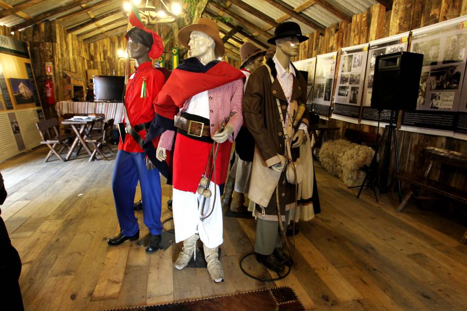 <strong>Rio Grande do Sul: pilcha</strong> Em festas populares gaúchas, a população costuma se vestir com roupas típicas e bem características. Esse conjunto é chamado pilcha e pode ser tanto feminino, quando masculino. Para os homens, a vestimenta é constituída pela bombacha - uma calça larga que é abotoada no tornozelo, enfiada dentro da bota e amarrada na cintura por uma faixa -, por uma camisa sob um lenço vermelho amarrado ao pescoço, por uma pala (tecido que lembra um poncho) e, por último, mas não menos importante, pelo chapéu