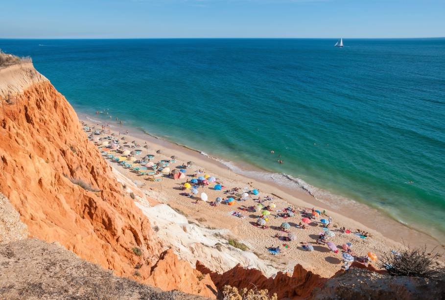 Com uma faixa de areia bem larga e extensa (cerca de 5,5 quilômetros), essa grandiosa praia é conhecida por suas falésias de coloração alaranjada e esbranquiçada que, em alguns pontos, chegam a medir 40 metros de altura. <a href="https://www.booking.com/landmark/pt/falesia-beach.pt-pt.html?aid=332455&label=viagemabril-praiasportugal" target="_blank" rel="noopener noreferrer"><em>Reserve o seu hotel perto da Praia da Falésia através do Booking.com</em></a>