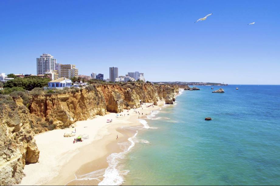 Ser uma das mais belas praias de <a href="https://viajeaqui.abril.com.br/paises/portugal" target="_blank" rel="noopener noreferrer">Portugal</a> tem seus preços: o local, durante o verão, está sempre cheio de turistas, mesmo com sua extensa faixa de areia, de 1,5 quilômetro. O lado bom é que, em seu entorno, existem várias e ótimas opções de bares e restaurantes. <a href="https://www.booking.com/district/pt/portimao/praia-da-rocha.html?aid=332455&label=viagemabril-praiasportugal" target="_blank" rel="noopener noreferrer"><em>Reserve o seu hotel em através do Booking.com</em></a>