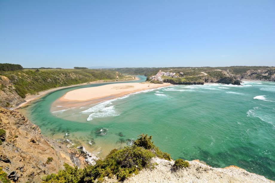 É durante a maré baixa que surge o melhor atributo dessa praia: as piscinas naturais! Ela também é cercada por falésias e, ao sul, conta com uma ilhota satélite, a Praia de Adegas. <a href="https://www.booking.com/city/pt/praia-de-odeceixe.en-gb.html?aid=332455&label=viagemabril-praiasportugal" target="_blank" rel="noopener noreferrer"><em>Reserve o seu hotel na praia de Odeceixe através do Booking.com</em></a>