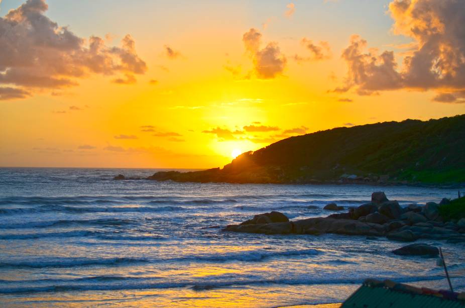 <strong>Praia do Rosa (SC)  </strong> Natureza bem preservada, centro pequeno de ruas estreitas e convidativas e trilhas interessantes pela Mata Atlântica que levam a diferentes praias fazem da Praia do Rosa um ótimo lugar para uma viagem a dois. No inverno é frio, mas é possível observar as baleias-francas, que podem ser vistas da praia mesmo ou em passeios de barco. A praia não tem barracas, as águas são verdes e o mar varia de agitado nas laterais à esquerda e à direita a bem calmo na Lagoa do Meio. Apesar de pequena (mas está crescendo bem rápido), o Rosa tem bons restaurantes e pousadas bastante confortáveis. <a href="https://www.booking.com/searchresults.pt-br.html?aid=332455&sid=605c56653290b80351df808102ac423d&sb=1&src=index&src_elem=sb&error_url=https%3A%2F%2Fwww.booking.com%2Findex.pt-br.html%3Faid%3D332455%3Bsid%3D605c56653290b80351df808102ac423d%3Bsb_price_type%3Dtotal%26%3B&ss=Praia+do+Rosa%2C+Santa+Catarina%2C+Brasil&checkin_monthday=&checkin_month=&checkin_year=&checkout_monthday=&checkout_month=&checkout_year=&no_rooms=1&group_adults=2&group_children=0&b_h4u_keep_filters=&from_sf=1&ss_raw=Praia+do+Rosa&ac_position=0&ac_langcode=xb&dest_id=900048708&dest_type=city&place_id_lat=-28.125&place_id_lon=-48.648998&search_pageview_id=762184f615260327&search_selected=true&search_pageview_id=762184f615260327&ac_suggestion_list_length=5&ac_suggestion_theme_list_length=0" target="_blank" rel="noopener"><em>Busque hospedagens na Praia do Rosa</em></a>